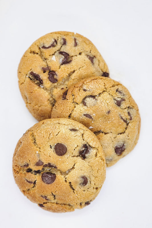 Sideway stack of chocolate chip cookies on a white background.