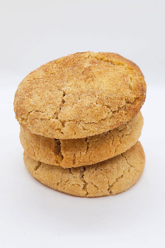 Stack of three cinnamon donuts on a white background.