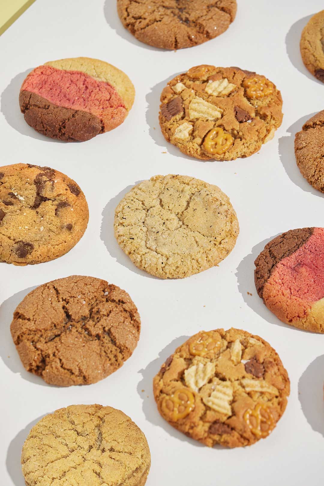 Cookie filled background with Happy Stack Cookies flavours on a white background.