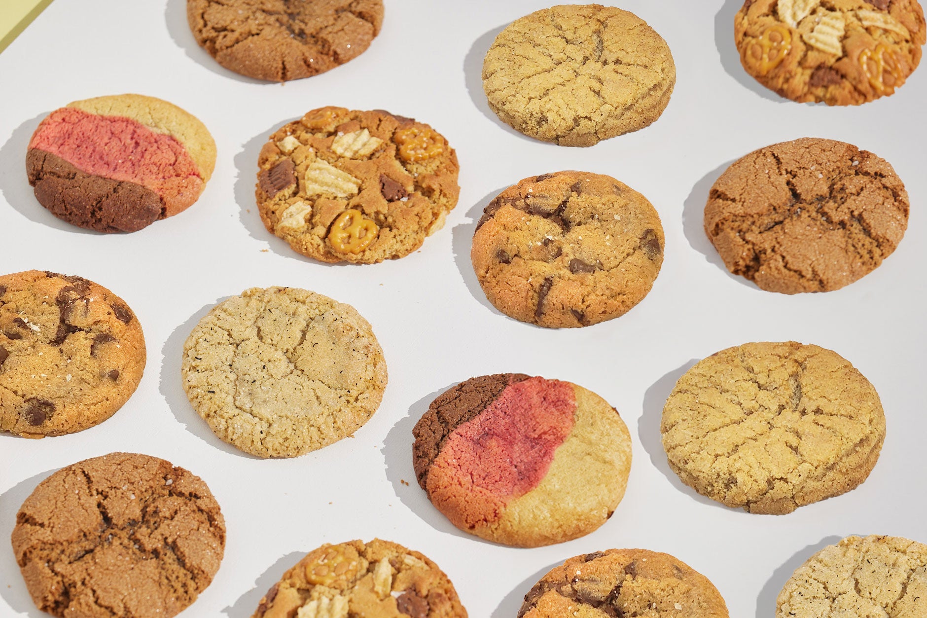 Cookie filled background with Happy Stack Cookies flavours on a white background.